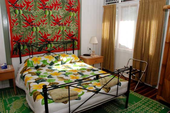 wrought iron bed and embroidered quilts with merging of Indonesian and Island design